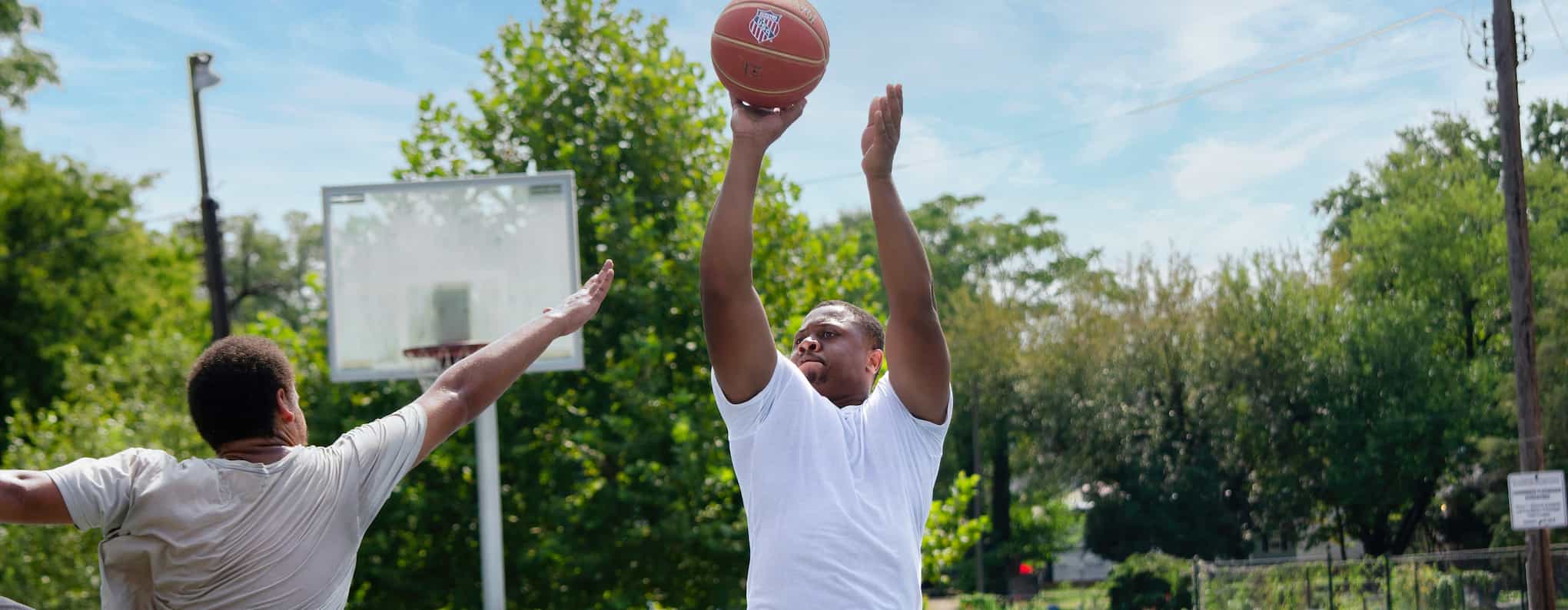 Two black men playing a casual game of basketball.