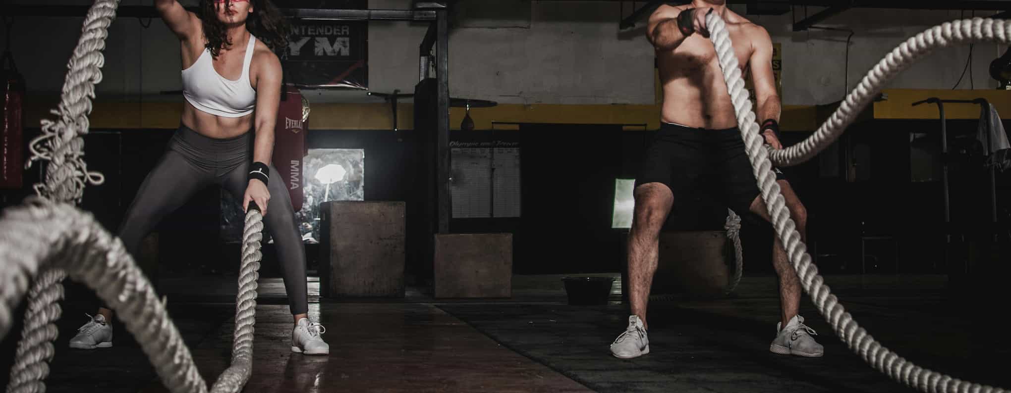 A woman and a man doing battle ropes.