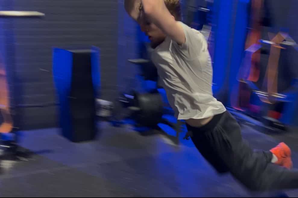 Jordan Johnson at the start of a bound, or broad jump in a gym.